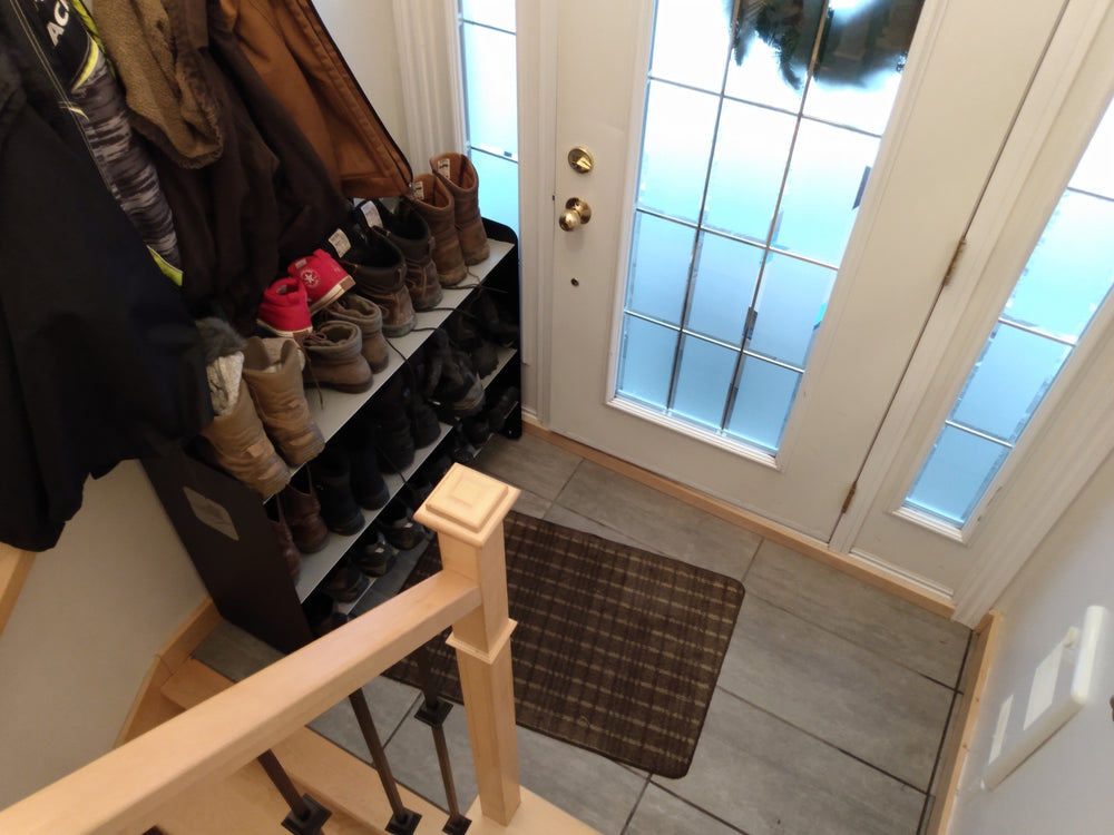 Winter boots on a three-shelf Titan rack in a home entryway